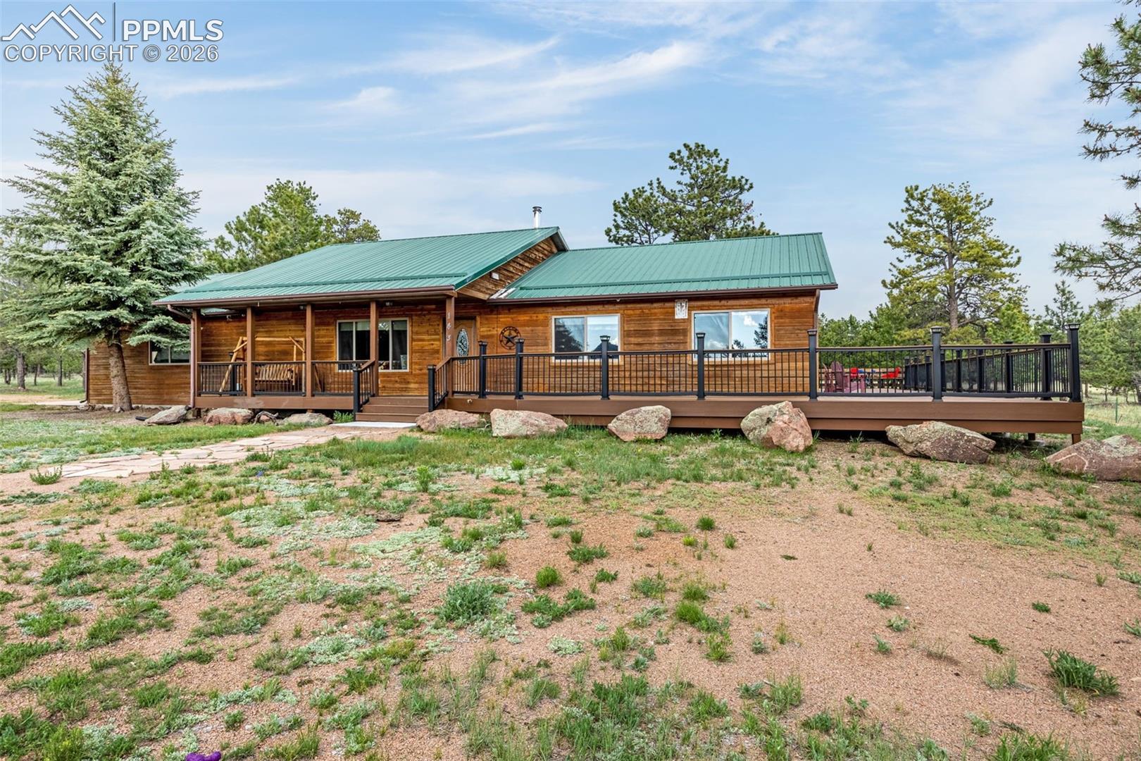 View of front of house with a metal roof and a porch