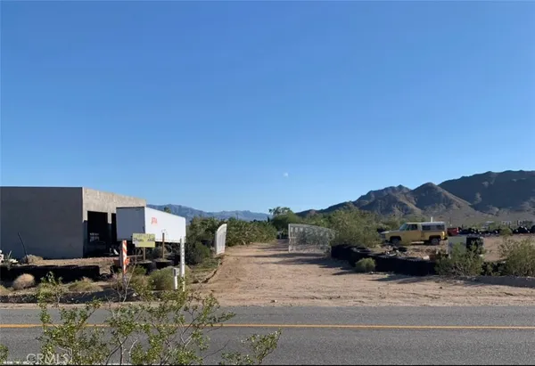 a view of a house with a yard and table and chairs under an umbrella