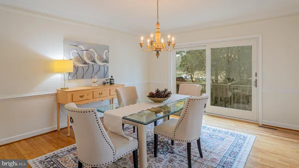 a dining room with furniture a chandelier and wooden floor