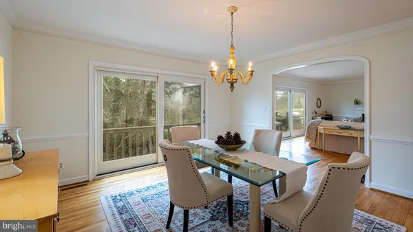 a view of a dining room with furniture wooden floor and a chandelier