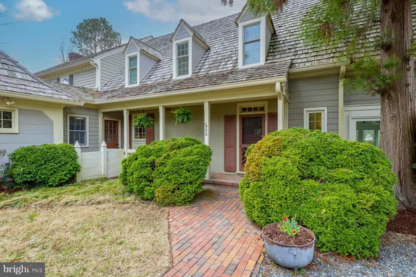 front view of a house with yard and potted plants