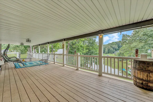 a view of a house with pool and chairs under an umbrella