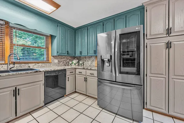 a kitchen with stainless steel appliances granite countertop a refrigerator and a stove