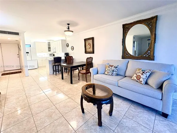 a living room with furniture a dining table and a mirror