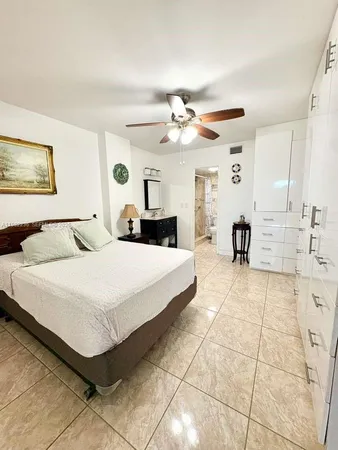 a spacious bedroom with a bed a chandelier and closet