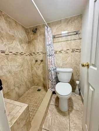 a bathroom with a toilet and a shower