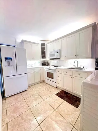 a kitchen with a stove a sink and a refrigerator