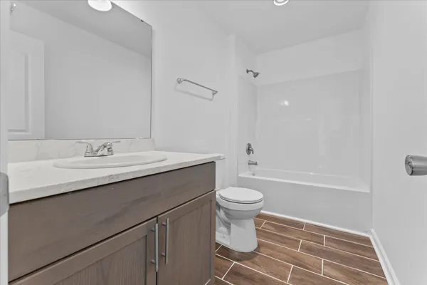 a bathroom with a sink toilet a mirror and bathtub