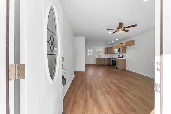a view of a kitchen with a white cabinets and wooden floor