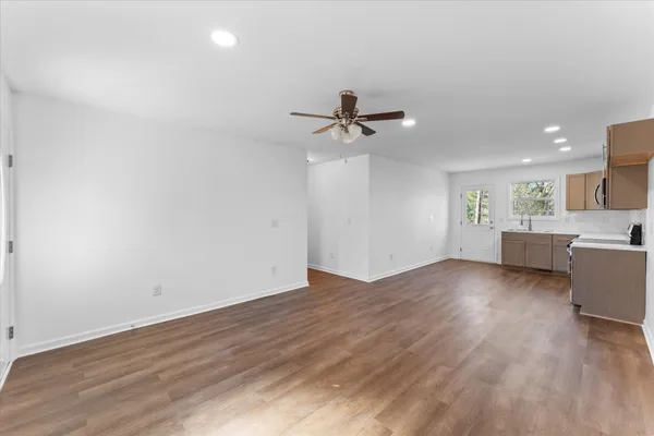 a view of a livingroom with a hardwood floor and a ceiling fan