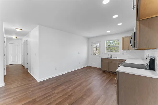 a view of a kitchen with wooden floor and a sink