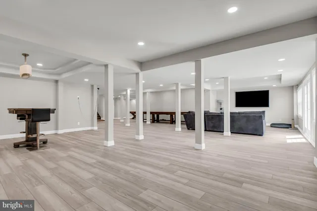 a view of a hallway with wooden floor and a bathroom with a glass door shower