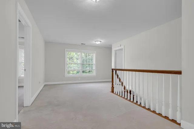 a view of a white house with a fountain and sitting area