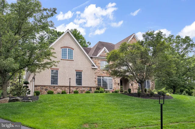 a front view of a house with a garden and trees
