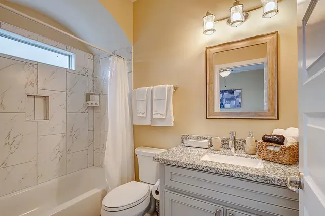 a bathroom with a granite countertop sink toilet and shower