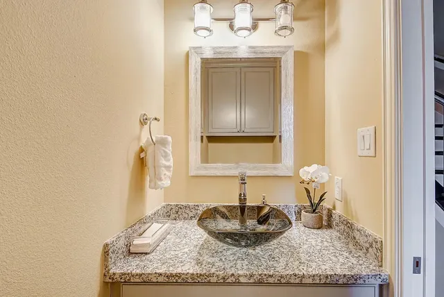 a bathroom with a granite countertop sink and a mirror