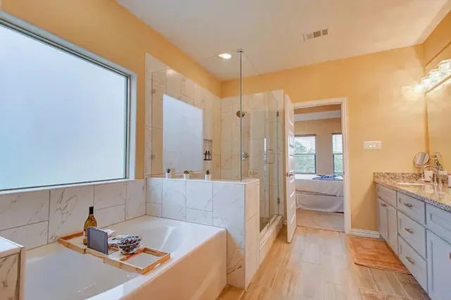 a bathroom with a tub sink and mirror