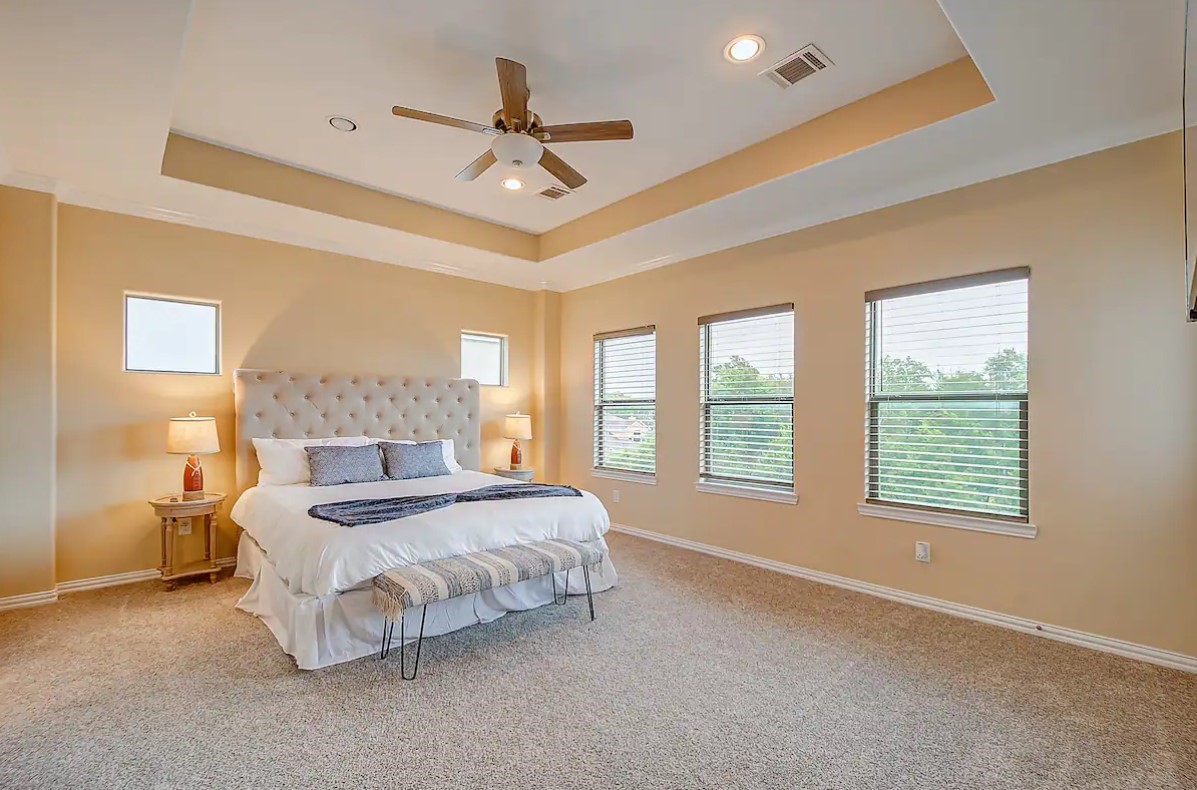 3909 Griggs Road Houston, TX 77021 - Photo 22 of 26 a spacious bedroom with a bed a chandelier and large window