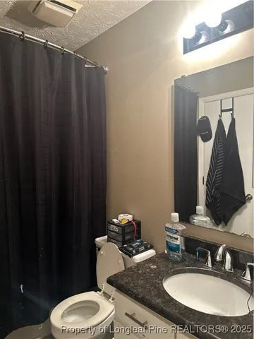 a bathroom with a sink vanity mirror and toilet