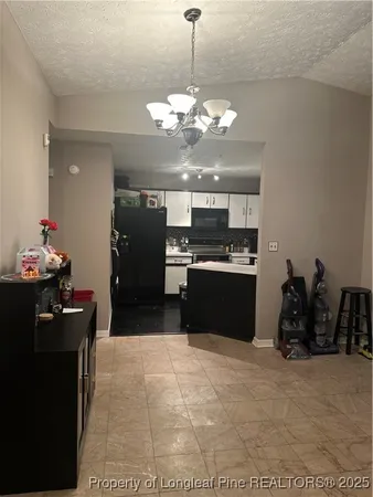 a kitchen with a chandelier and refrigerator