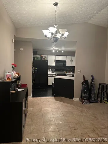 a kitchen with a chandelier and refrigerator