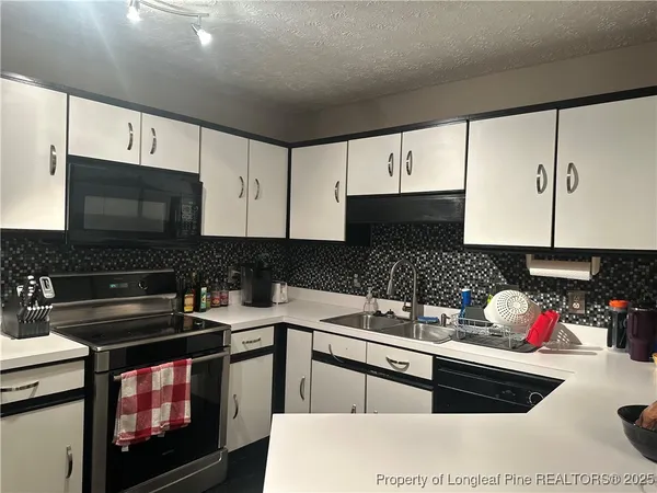 a kitchen with a sink stove top oven and microwave
