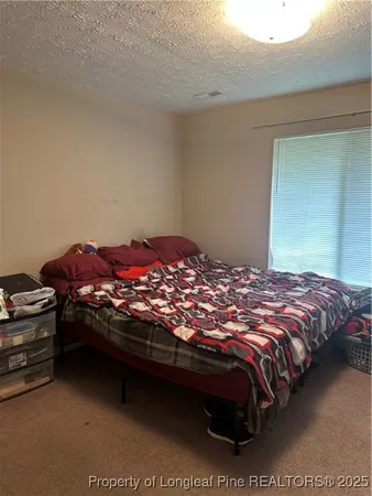 a bedroom with a bed dresser and a lamp