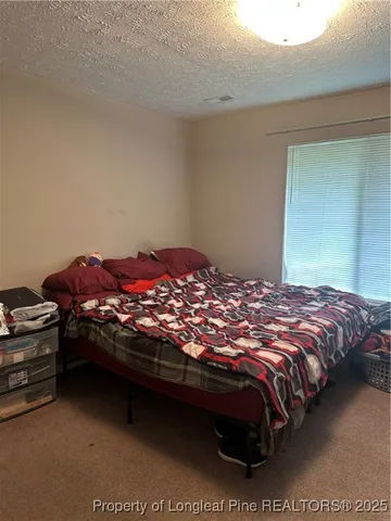 a bedroom with a bed dresser and a lamp