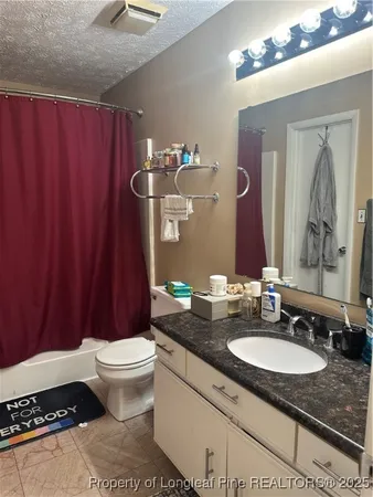 a bathroom with a granite countertop sink toilet and a mirror