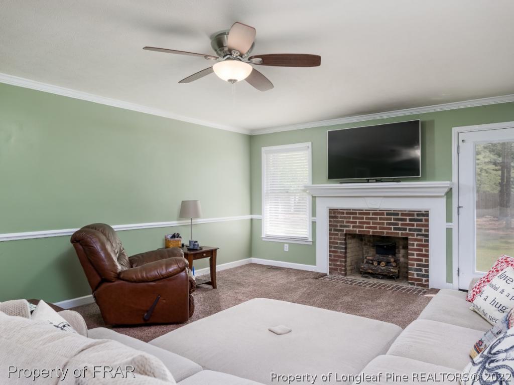 7790 Dragonhead Road Fayetteville, NC 28311 - Photo 11 of 36 a living room with furniture a fireplace and a flat screen tv