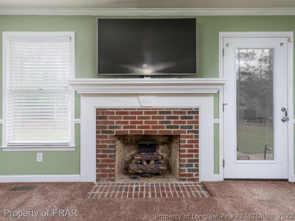 7790 Dragonhead Road Fayetteville, NC 28311 - Photo 14 of 36 a living room with a fireplace and a flat screen tv