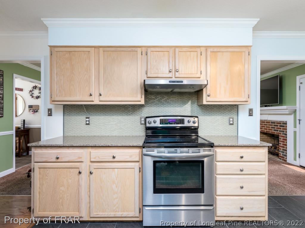 7790 Dragonhead Road Fayetteville, NC 28311 - Photo 18 of 36 a kitchen with stainless steel appliances granite countertop a stove and a microwave