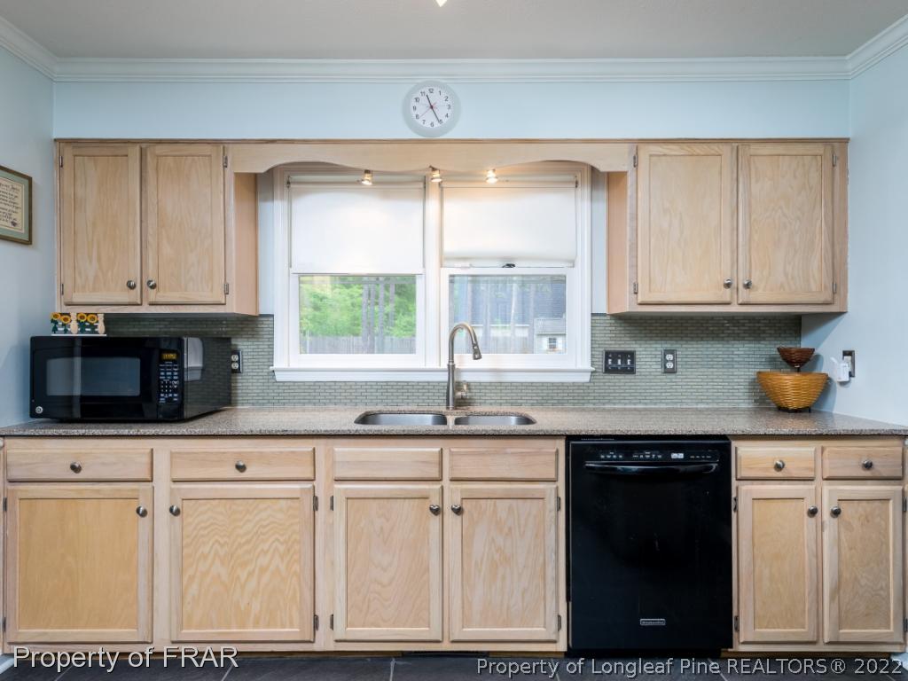 7790 Dragonhead Road Fayetteville, NC 28311 - Photo 19 of 36 a kitchen with granite countertop a sink stainless steel appliances and cabinets