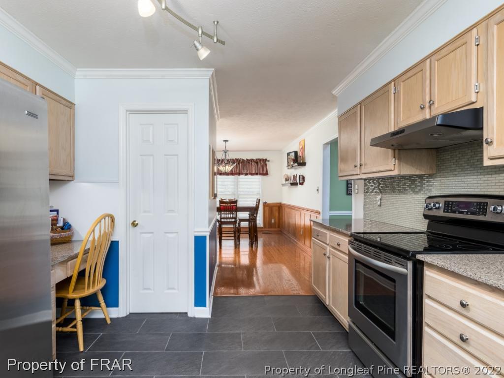 7790 Dragonhead Road Fayetteville, NC 28311 - Photo 20 of 36 a kitchen with stainless steel appliances granite countertop a stove and a refrigerator