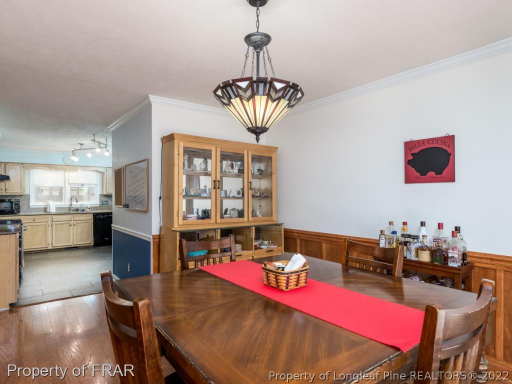7790 Dragonhead Road Fayetteville, NC 28311 - Photo 23 of 36 a view of a dining room with furniture a chandelier and wooden floor