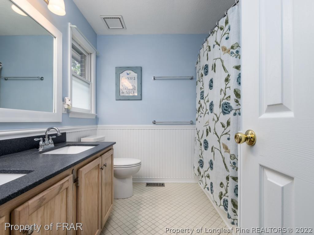 7790 Dragonhead Road Fayetteville, NC 28311 - Photo 27 of 36 a bathroom with a sink a toilet and a shower curtain
