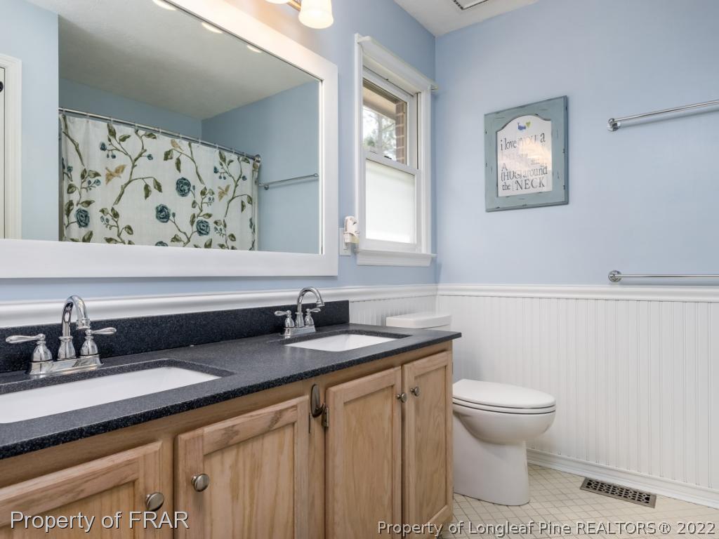 7790 Dragonhead Road Fayetteville, NC 28311 - Photo 28 of 36 a bathroom with a granite countertop sink and a toilet