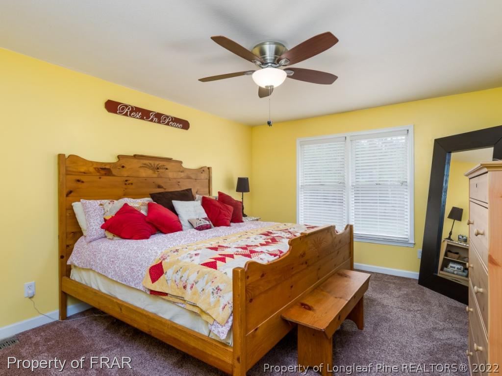 7790 Dragonhead Road Fayetteville, NC 28311 - Photo 30 of 36 a bedroom with a bed and a chandelier