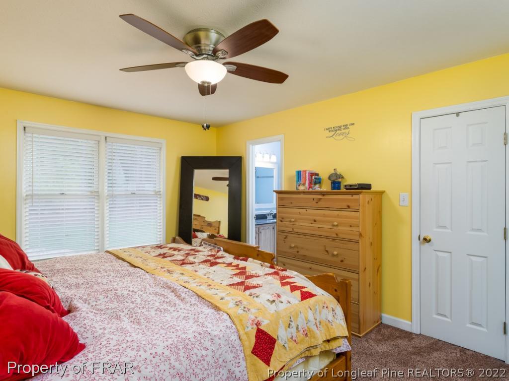 7790 Dragonhead Road Fayetteville, NC 28311 - Photo 31 of 36 a bedroom with a bed and a chandelier