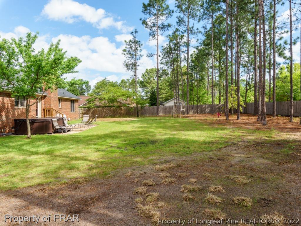 7790 Dragonhead Road Fayetteville, NC 28311 - Photo 7 of 36 a view of a house with a big yard and palm trees