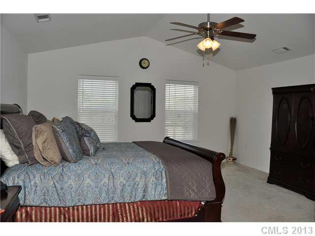 205 Lind Point Lane Monroe, NC 28110 - Photo 11 of 16 a bedroom with a bed window and a chandelier