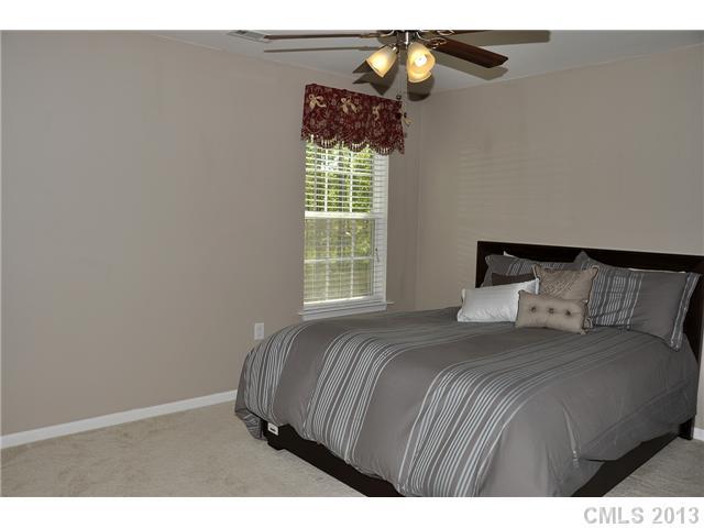 205 Lind Point Lane Monroe, NC 28110 - Photo 13 of 16 a bedroom with a bed and a chandelier