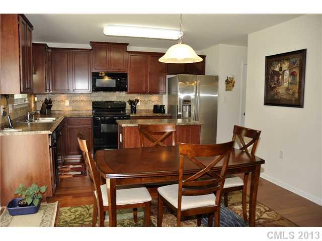 205 Lind Point Lane Monroe, NC 28110 - Photo 7 of 16 a kitchen with a table chairs refrigerator and microwave