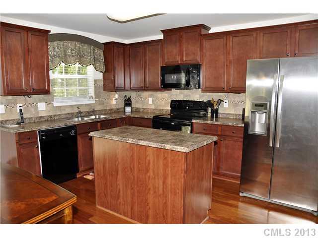 205 Lind Point Lane Monroe, NC 28110 - Photo 8 of 16 a kitchen with granite countertop stainless steel appliances a sink stove and refrigerator