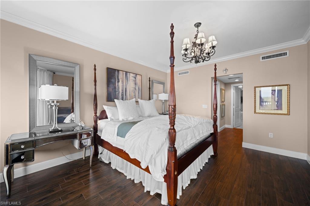 1050 Borghese Lane, Unit 902 Naples, FL 34114 - Photo 30 of 50 Bedroom with dark wood-type flooring, a notable chandelier, and crown molding