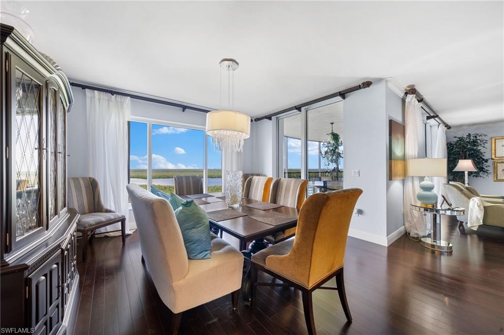 1050 Borghese Lane, Unit 902 Naples, FL 34114 - Photo 8 of 50 Dining room featuring a healthy amount of sunlight, a notable chandelier, and dark hardwood / wood-style flooring