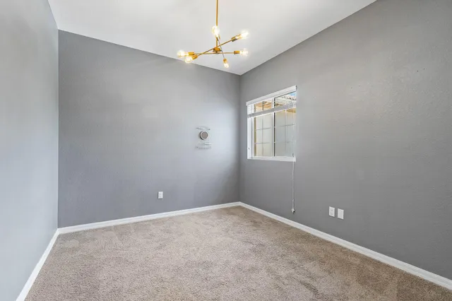 an empty room with windows and ceiling fan
