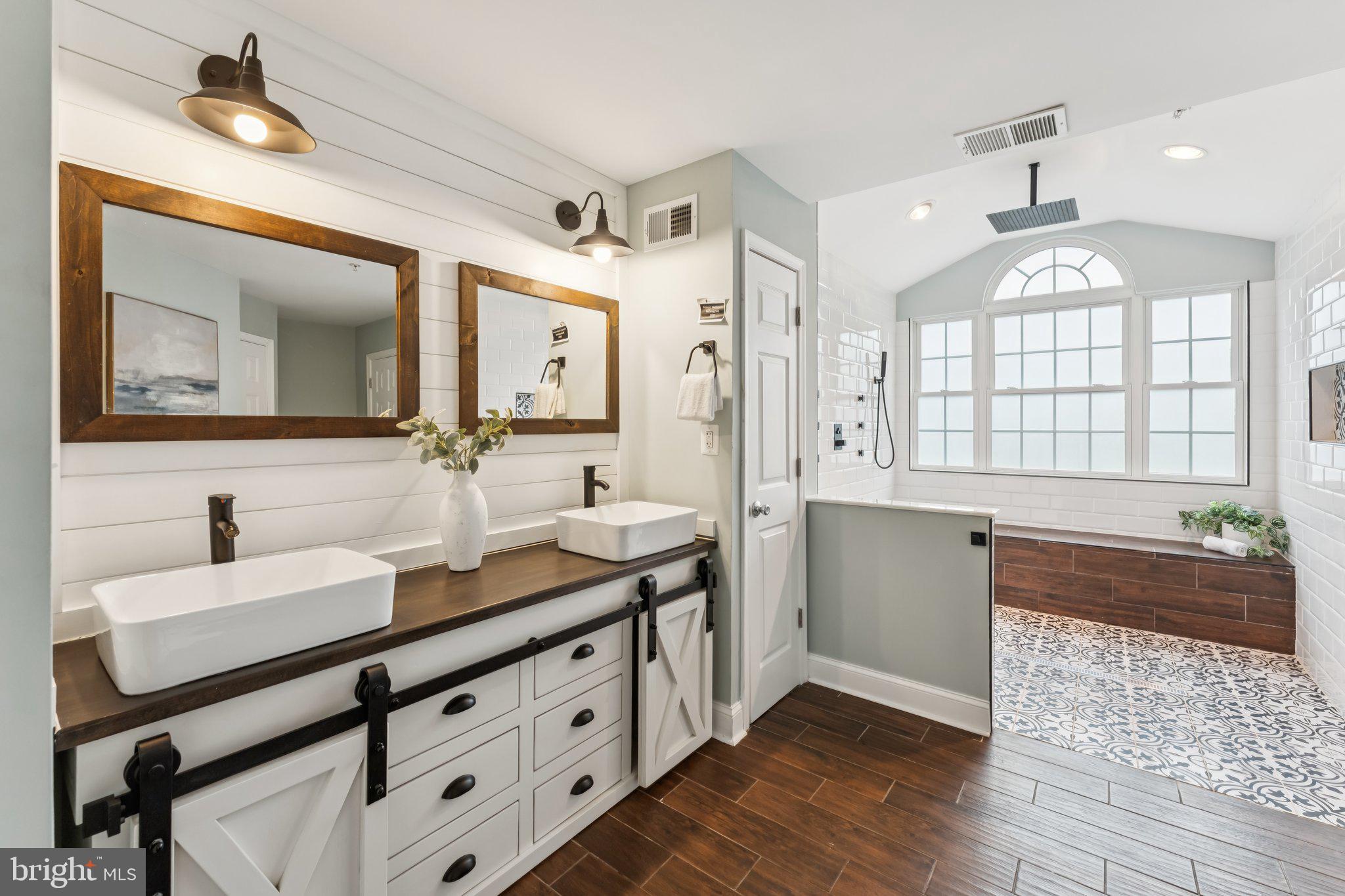 14520 Fairdale Road Silver Spring, MD 20905 - Photo 19 of 50 a spacious bathroom with a double vanity sink a mirror a bathtub and next to a window