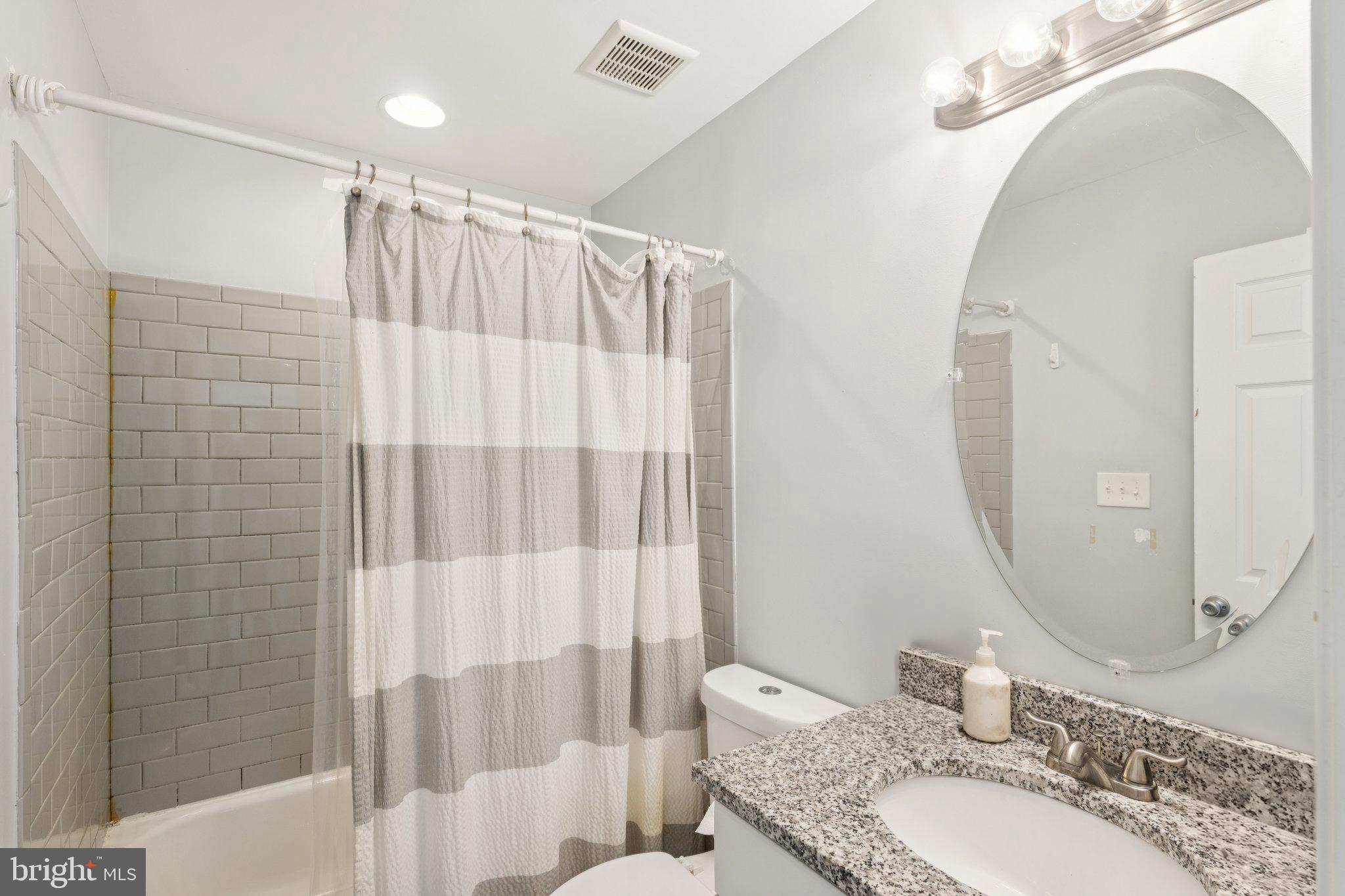 14520 Fairdale Road Silver Spring, MD 20905 - Photo 24 of 50 a bathroom with a granite countertop sink a mirror and a shower