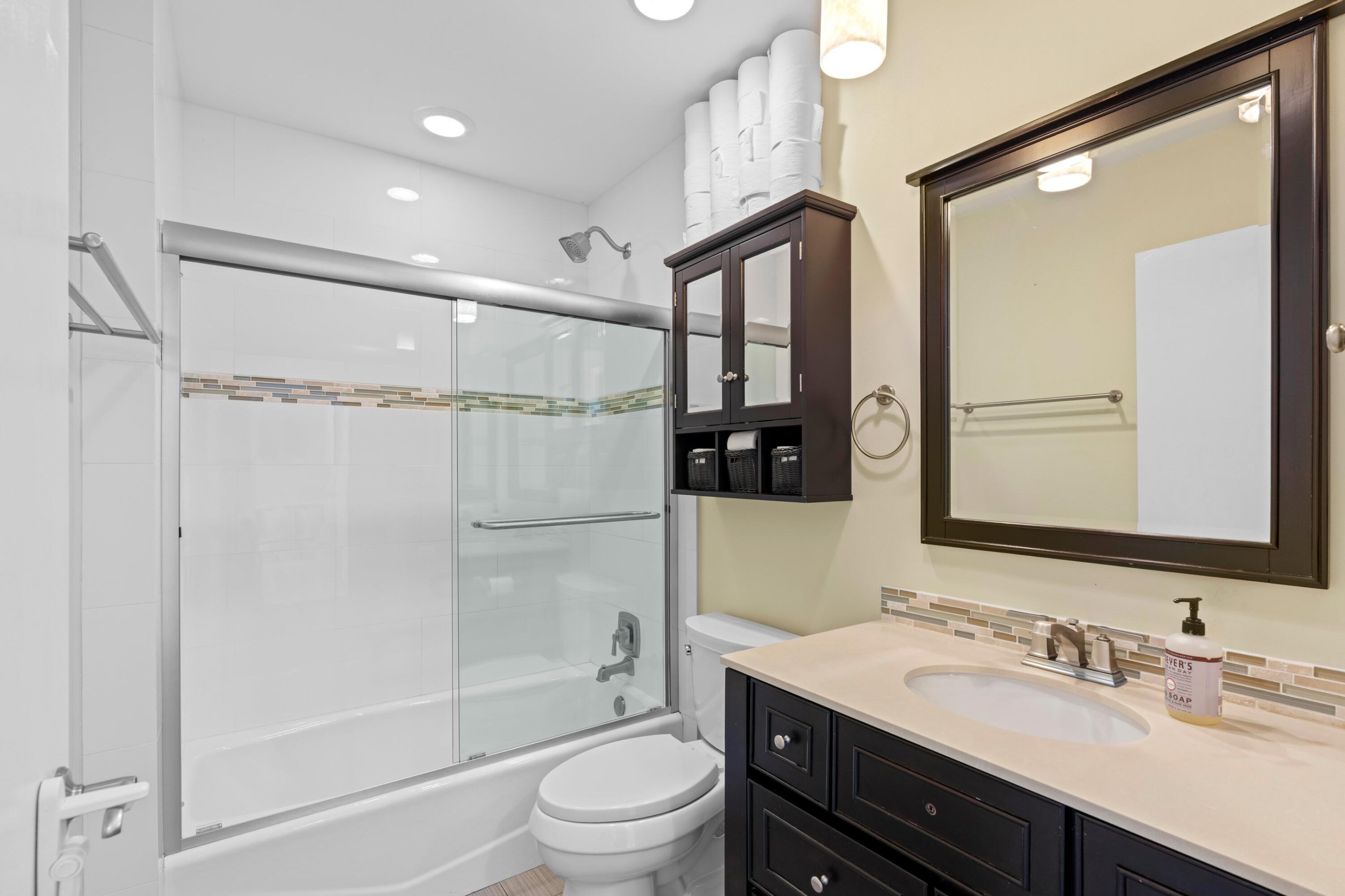 8584 Shawe Way Boca Raton, FL 33433 - Photo 15 of 43 a bathroom with a double vanity sink toilet mirror and shower